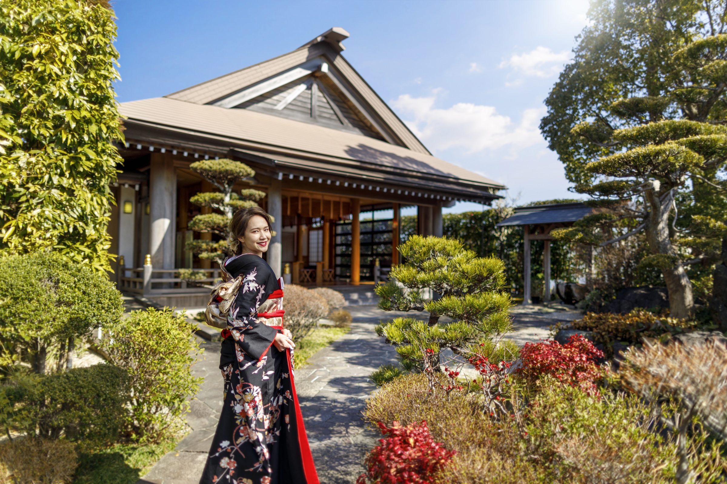 賀寿殿の庭園に佇む黒引き振袖の花嫁｜ザ・オランジェガーデン五十鈴川（三重県伊勢市の結婚式場）