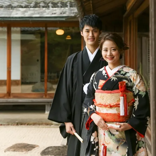 日本家屋を背にした紋付袴と色打掛のおふたり｜伊勢おかげさま婚