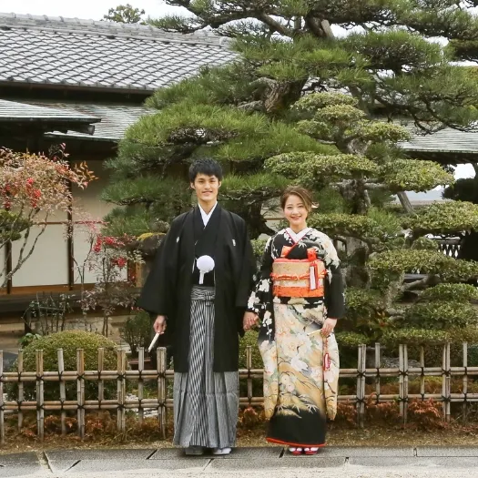 瓦屋根の日本家屋前に並ぶ和装のおふたり｜伊勢おかげさま婚