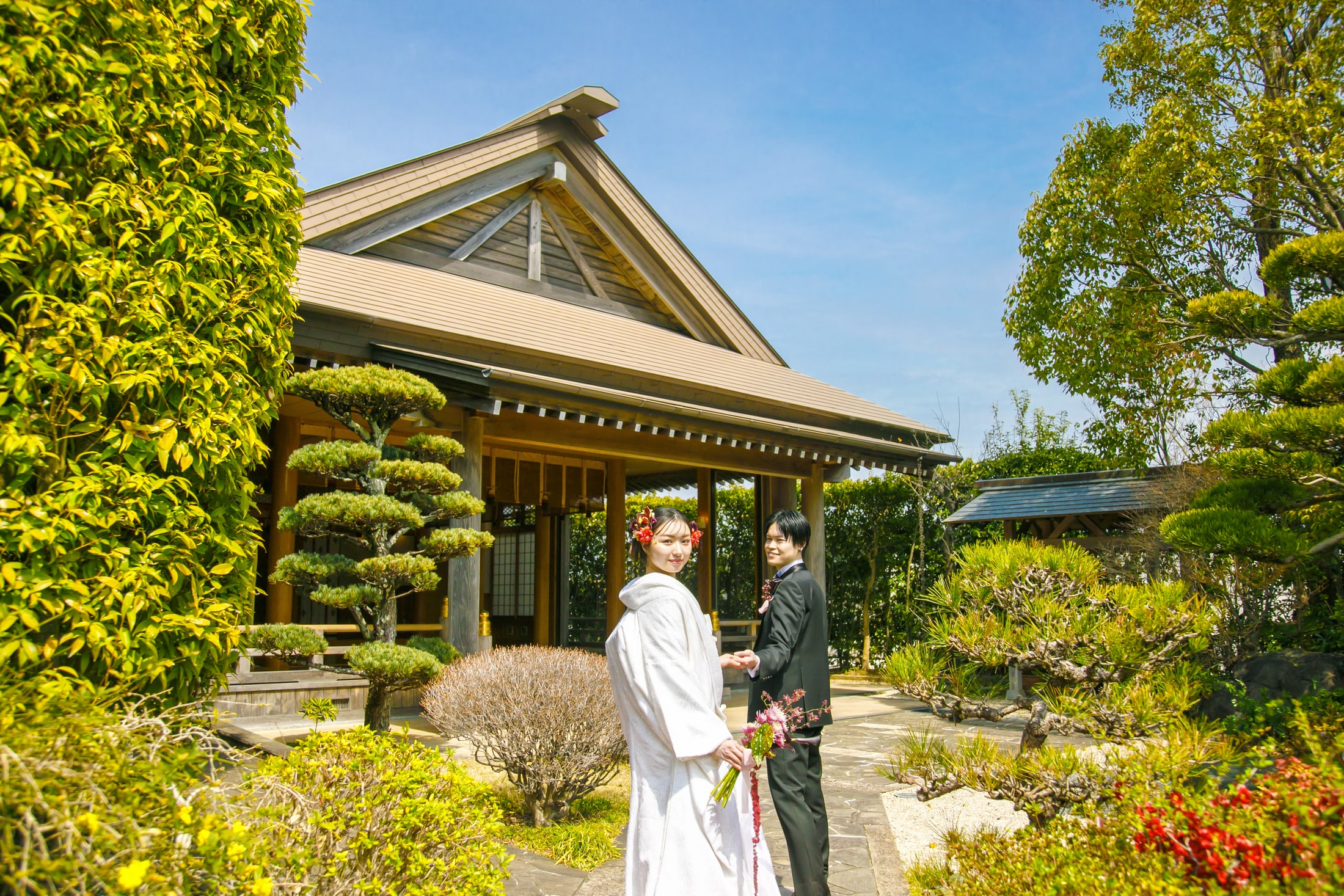 賀寿殿の庭園に佇む和装のおふたり｜ザ・オランジェガーデン五十鈴川（三重県伊勢市の結婚式場）